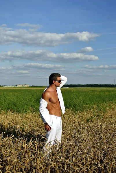 Bodybuilder klädd i vitt på fältet — Stockfoto