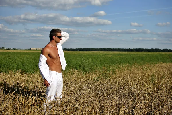 Bodybuilder gekleed in het wit op het veld — Stockfoto