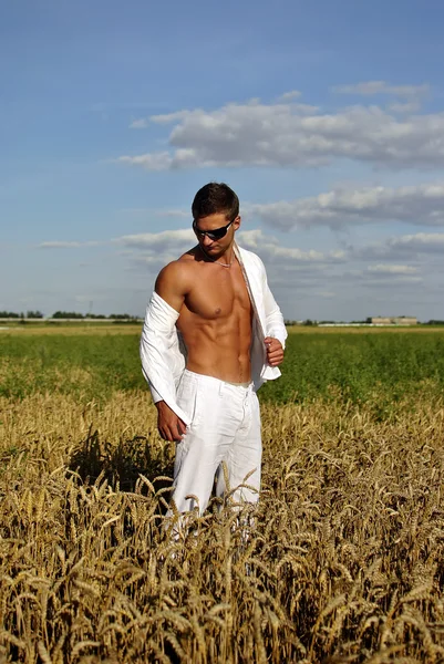 Bodybuilder dressed in white on the field — Stock Photo, Image
