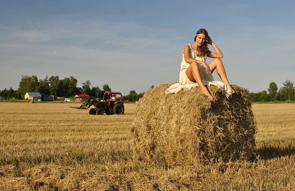 Menina em uma roupa rural sentada no palheiro — Fotografia de Stock