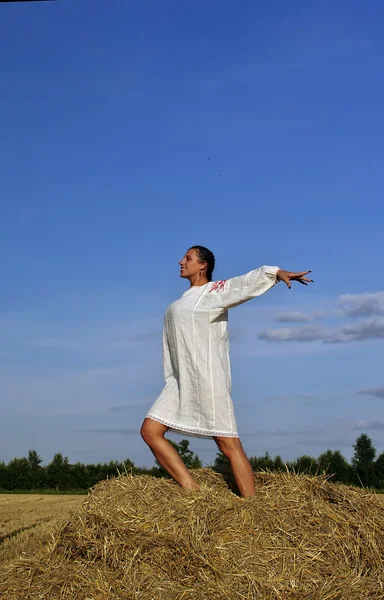 Meisje in klederdracht Russische staande op een hooiberg — Stockfoto