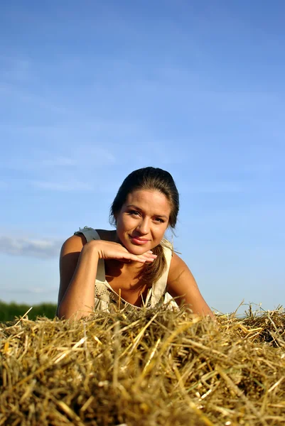 Dziewczyna w tradycyjnych strojach rosyjskich spoczywa na stogu siana — Zdjęcie stockowe