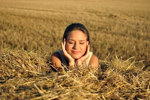 Girl in traditional Russian costume resting on a haystack — Stock Photo, Image