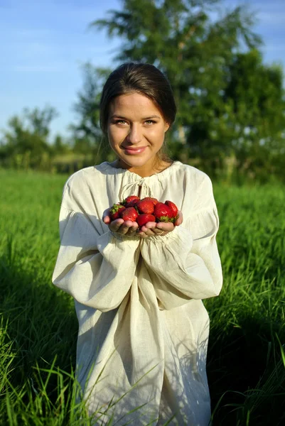 Chica en una camisa de lino, sosteniendo una fresa en la mano — Foto de Stock