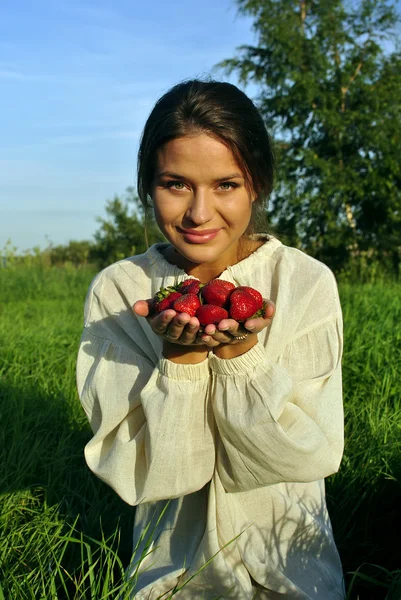 手でイチゴを押しリネンのシャツの女の子 — Stockfoto