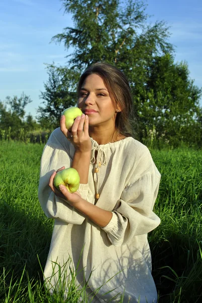 Flicka i en linne skjorta, hålla äpplen — Stockfoto