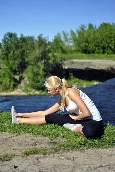 Flickan gör övning nära ett vattenfall — Stockfoto