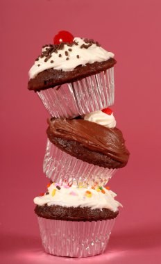 Three chocolate cupcakes stacked on end clipart