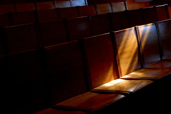 stock image Rows of church pews with stream of light