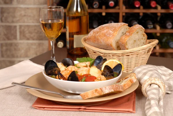 Bowl of seafood soup with wine and rustic bread — Stock Photo, Image