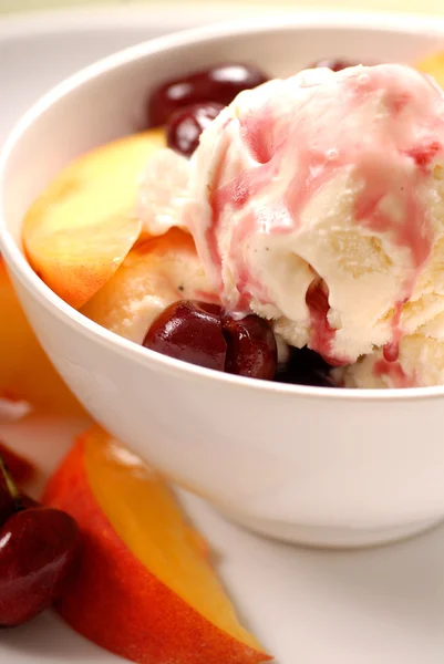 Bowl of ice cream with peaches and cherries — Stock Photo, Image
