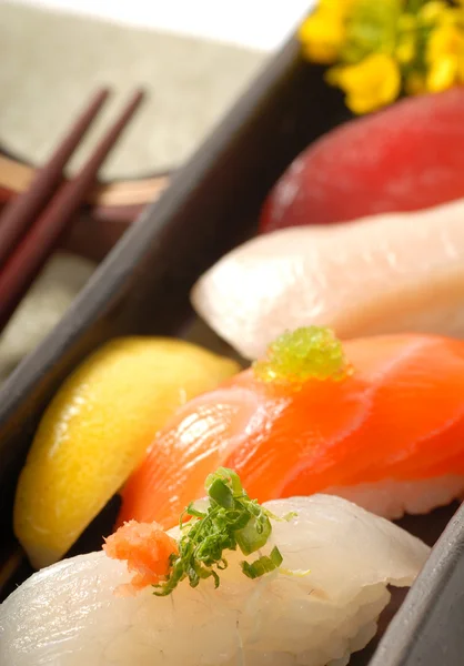 Sushi nigiri japonês com palitos de limão e costeleta — Fotografia de Stock