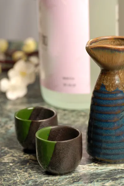 stock image Japanese sake setup with flowers in background