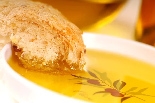 Кусок хрустящего хлеба в миске оливкового масла — стоковое фото