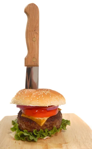 Cheeseburger with knife in it — Stock Photo, Image