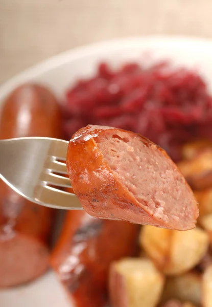 Smoked sausage on a fork — Stock Photo, Image