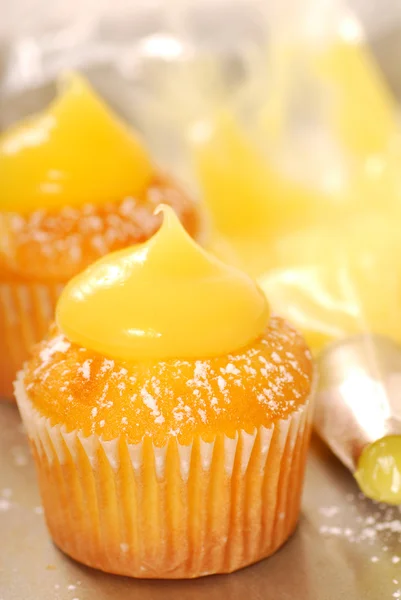 Decorating vanilla cupcakes — Stock Photo, Image