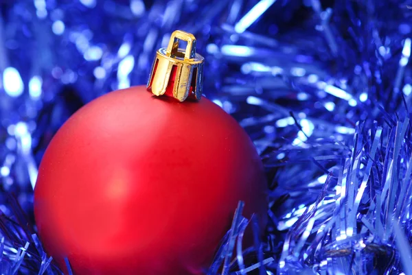 Красный рождественский орнамент на голубой гирлянде — стоковое фото