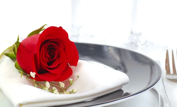 Rosa roja en un plato de cena — Foto de Stock