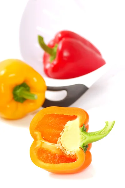 Orange, yellow and red bell peppers with a strainer — Stock Photo, Image