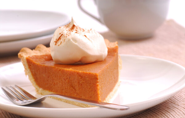 Slice of pumpkin pie with whipped cream