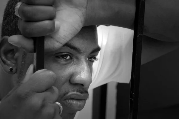 Ansiktet av en arg afroamerikanska mannen bakom järnstänger — Stockfoto