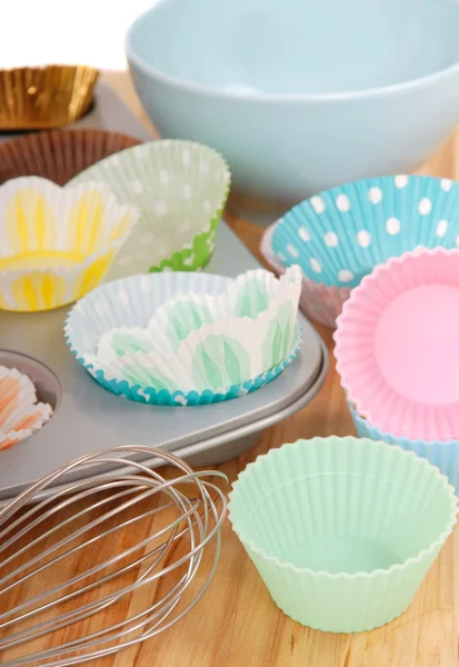 Verschiedene Cupcake-Liner mit Drahtbesen — Stockfoto