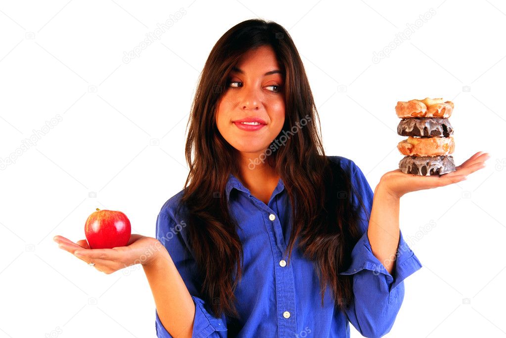 Young woman deciding betwen apple or donuts