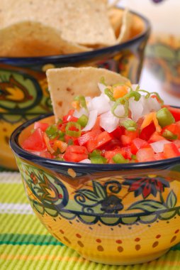 Spicy salsa with tortilla chips clipart