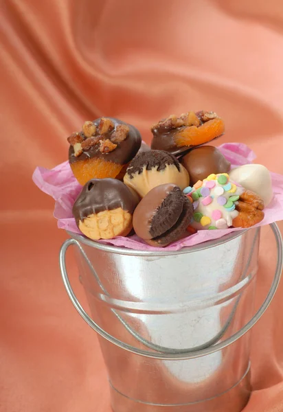 Silberner Eimer mit einer Vielzahl von mit Schokolade überzogenen Bonbons und — Stockfoto