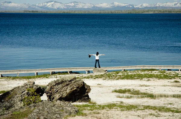 Mulher estica braços fora sobre o lago — Fotografia de Stock