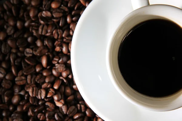 Tasse Kaffee mit Kaffeebohnen, Detail, fokussiert auf Tasse — Stockfoto