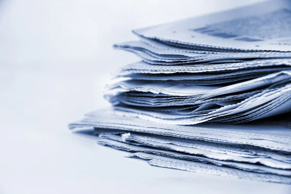 Zeitungen stapeln sich auf weißem Hintergrund — Stockfoto