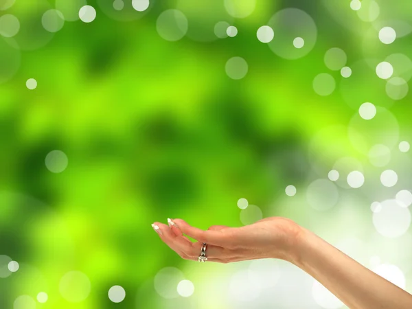 Concepto con mano de mujer sobre fondo verde borroso — Foto de Stock