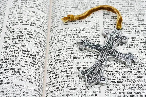 Открытая библия с серебряным крестом — стоковое фото
