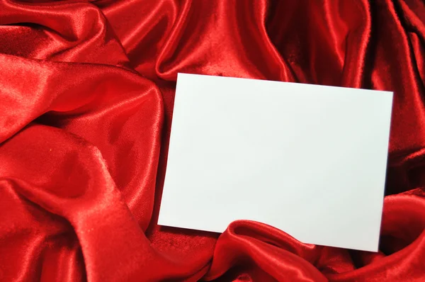 Prázdná karta na červené hedvábí — Stock fotografie