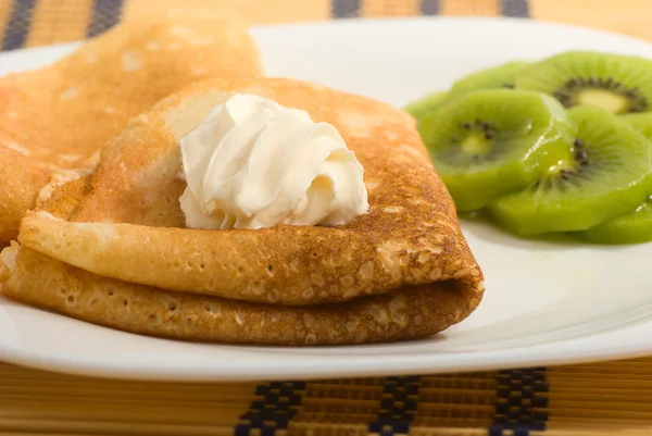 Pancakes with cream and kiwi fruit — Stock Photo, Image