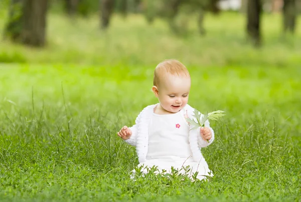 Schattig klein meisje in het gras — Stockfoto