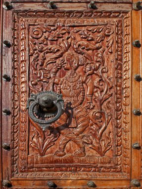Low relief carved wood with a Beautiful metal Knocker clipart