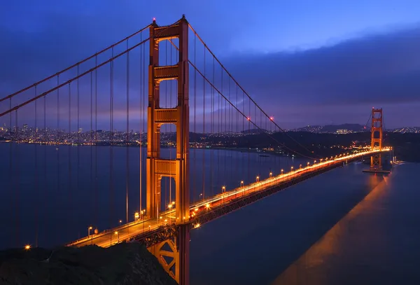 Golden Gate Bridge Sunset Skies Evening with Lights of San — стоковое фото