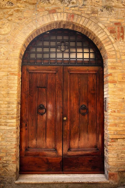 Antyczny brązowy drzwi średniowieczne miasto san gimignano Toskania z kamienia — Zdjęcie stockowe