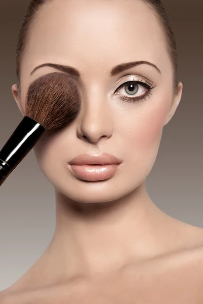 stock image Portrait of a beautiful woman with a make up brush