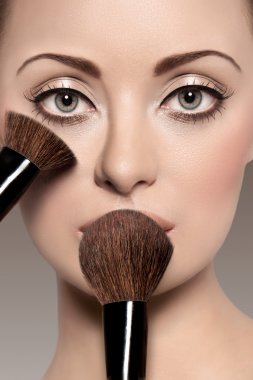 Portrait of a beautiful woman with a make up brush clipart