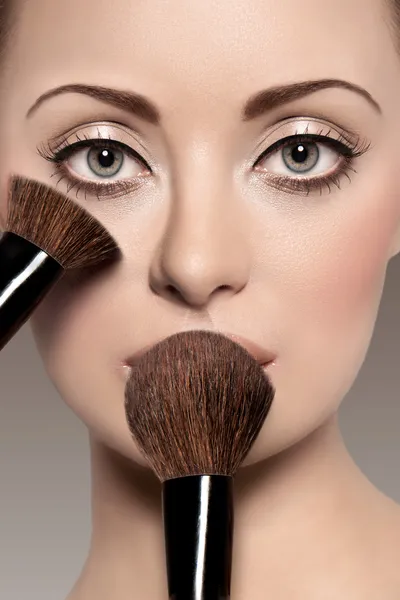 Portrait of a beautiful woman with a make up brush — Stock Photo, Image