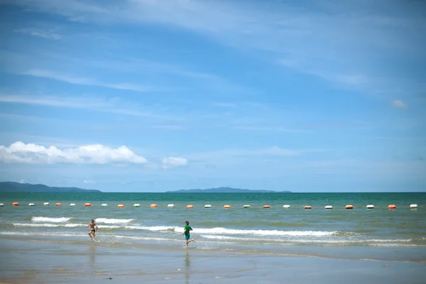 Der Junge und das Mädchen rennen an einem Strand — Stockfoto