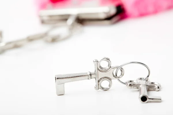 Pink fluffy handcuffs with key — Stock Photo, Image