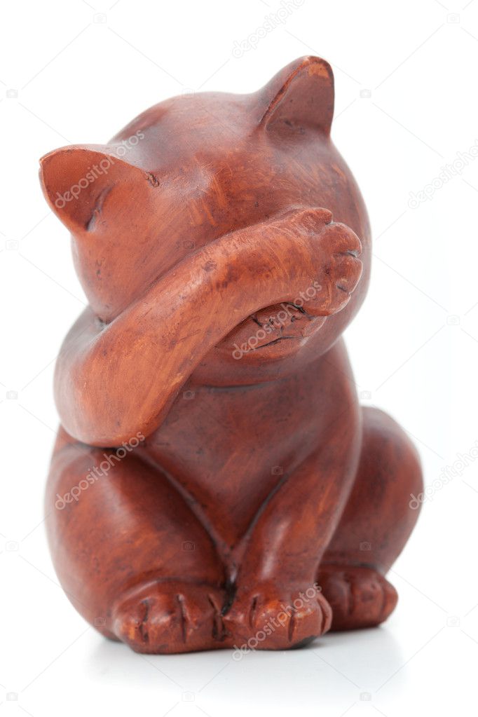 I see nothing concept. Wooden statuette of cat over white background.