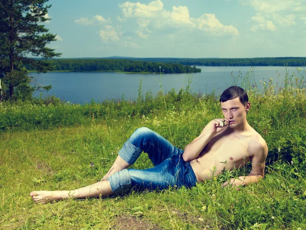 Ung mann ligger på engen – stockfoto