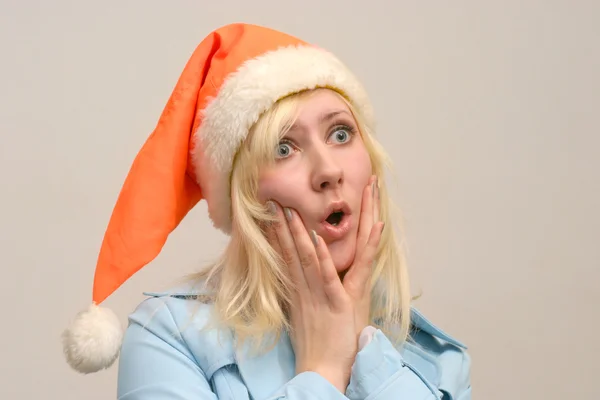 Vyděšená dívka s Santa čepice — Stock fotografie