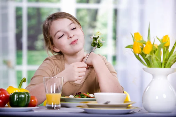 Молодая девушка ест салат дома. Студийная съемка — стоковое фото